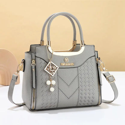 Bolso bandolera para mujer con costuras en forma de V, herrajes dorados, múltiples compartimentos y asa superior.