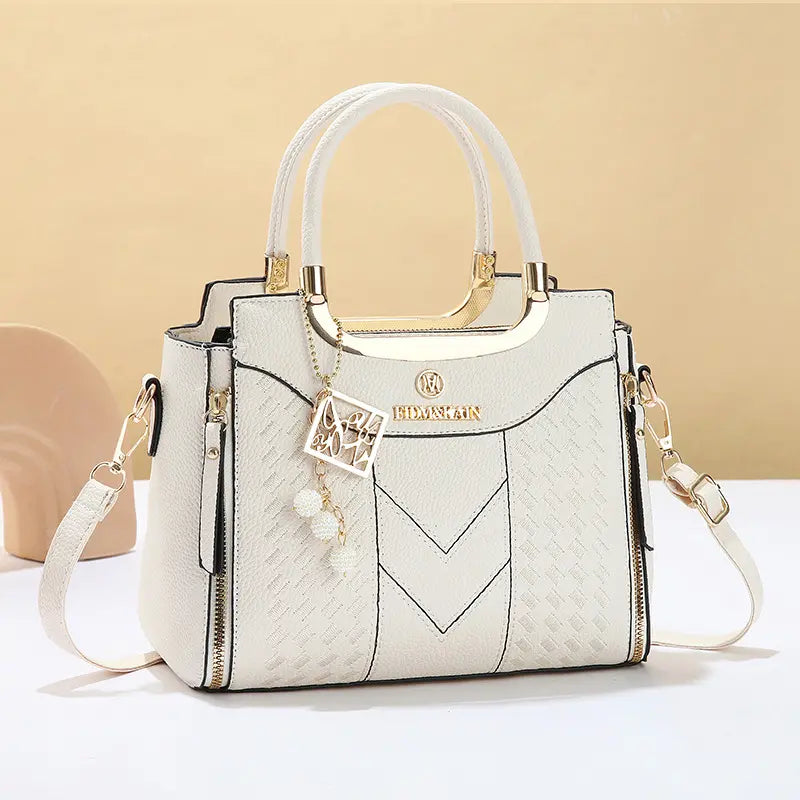 Bolso bandolera para mujer con costuras en forma de V, herrajes dorados, múltiples compartimentos y asa superior.