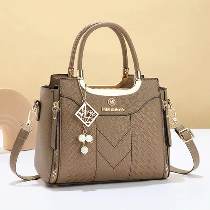 Bolso bandolera para mujer con costuras en forma de V, herrajes dorados, múltiples compartimentos y asa superior.
