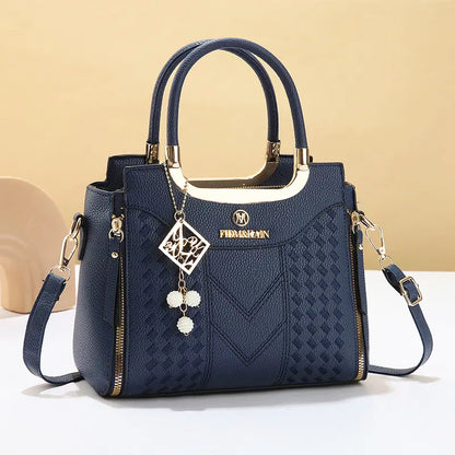 Bolso bandolera para mujer con costuras en forma de V, herrajes dorados, múltiples compartimentos y asa superior.